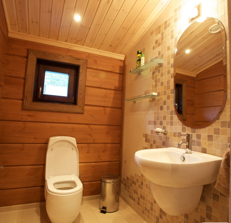 Туалет в деревянном доме с окном